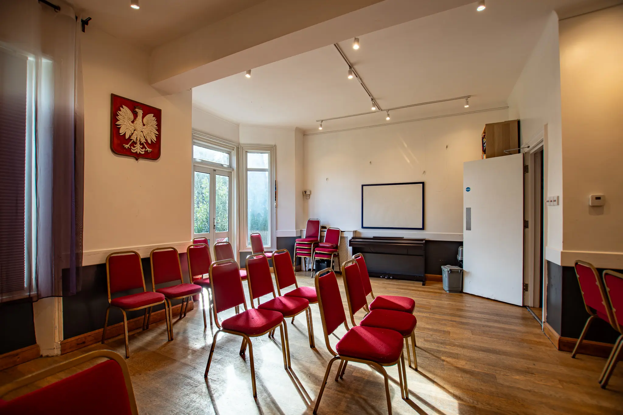 High quality HDR interior photography of a community hall with red chairs in London